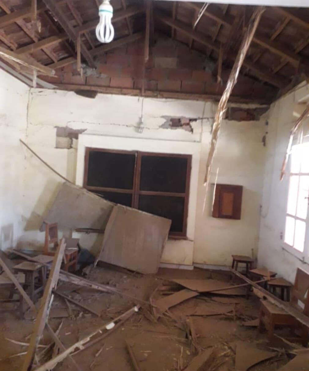 Le grand parloir avec ses meubles cassés, des débris sur le sol, les murs et le plafond endommagés.